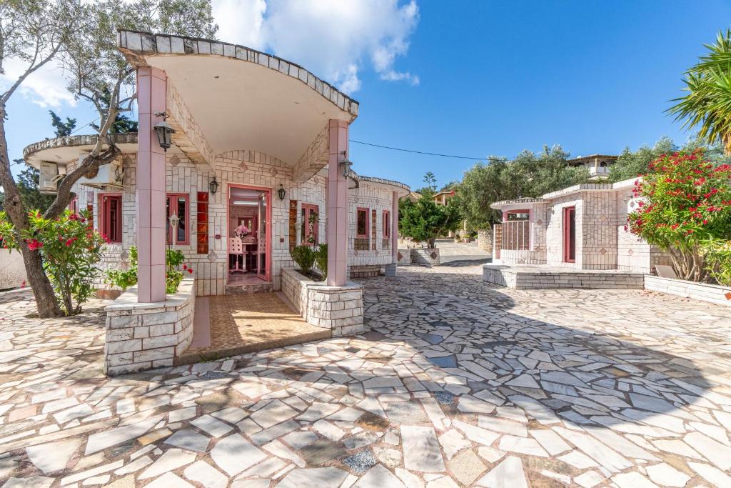 an old house with a stone driveway at Paco's Resort Barbie House in Oziás