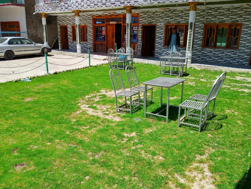 a group of chairs and a table in the grass at Nambal Hotel, Kalam in Kalām