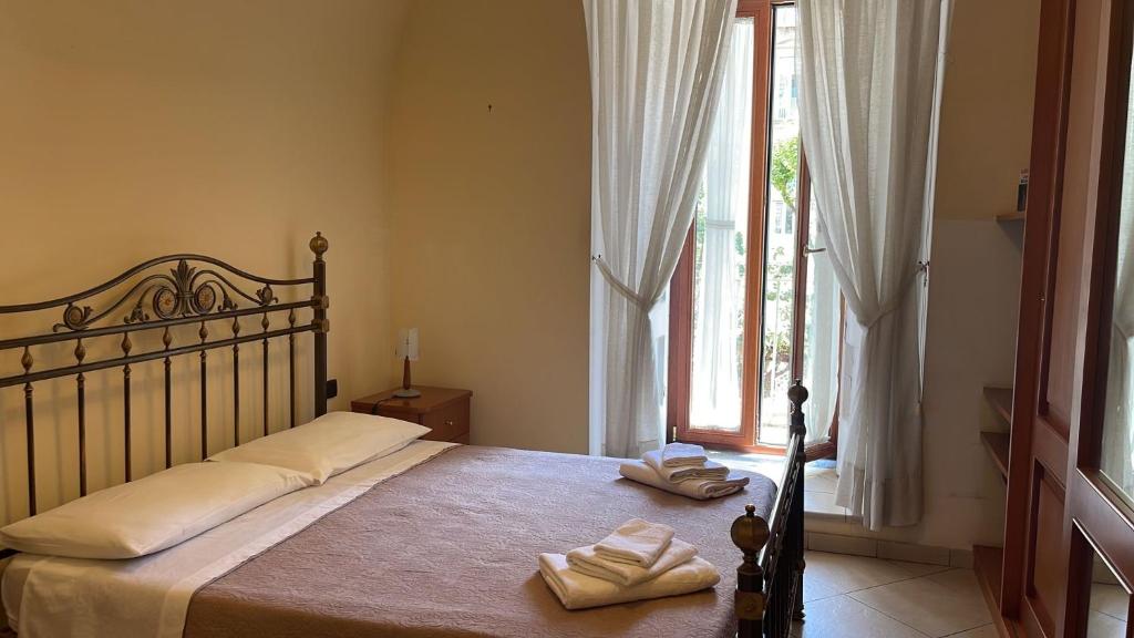 a bedroom with a bed with two towels on it at Bellini Holiday Home - Appartamento con balcone NAPOLI in Naples