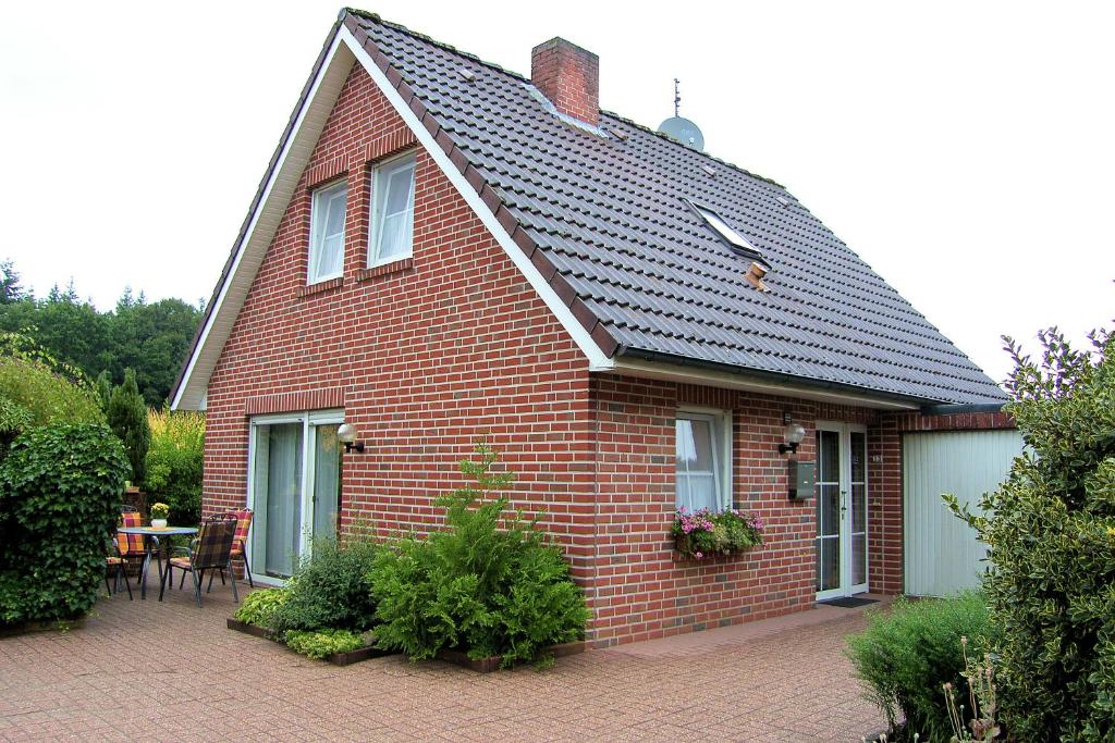 a red brick house with a table and chairs at Jautz RE13 in Sögel