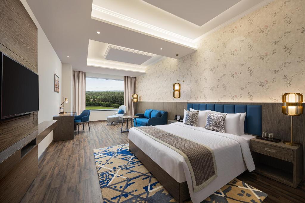 une chambre d'hôtel avec un lit et une télévision dans l'établissement Fortune Park, Hoshiarpur - Member ITC's Hotel Group, à Hoshiārpur