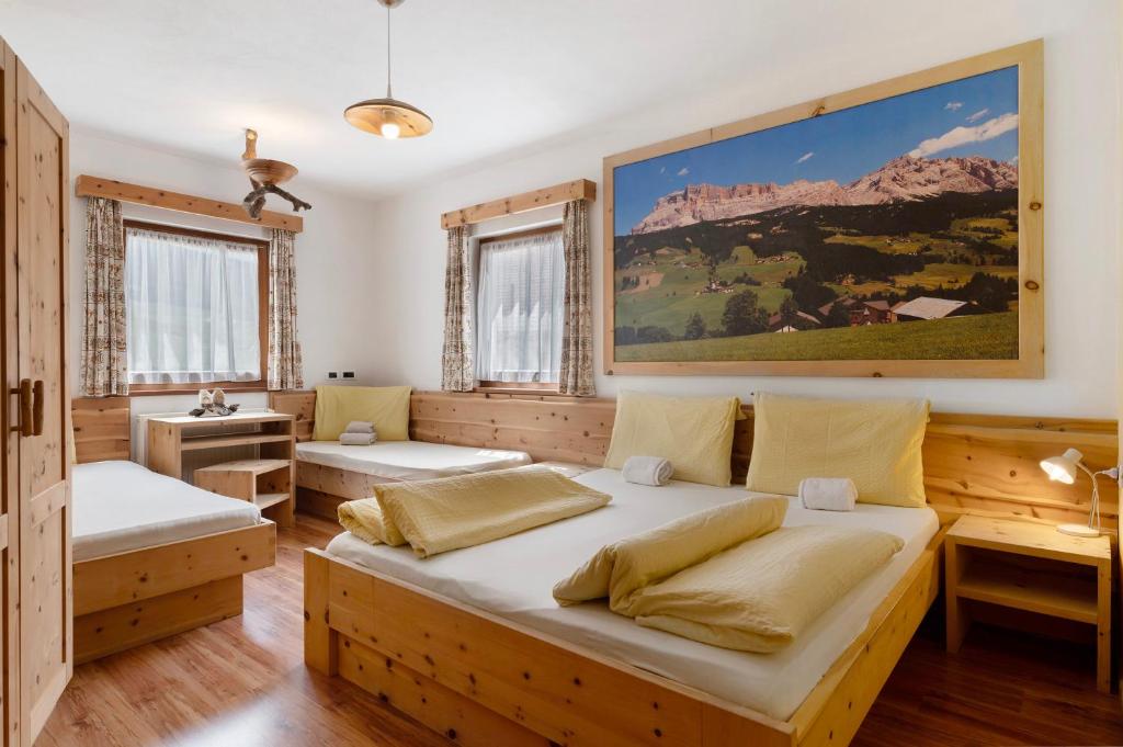 a bedroom with two beds and a painting on the wall at Paracia App Cir in Badia