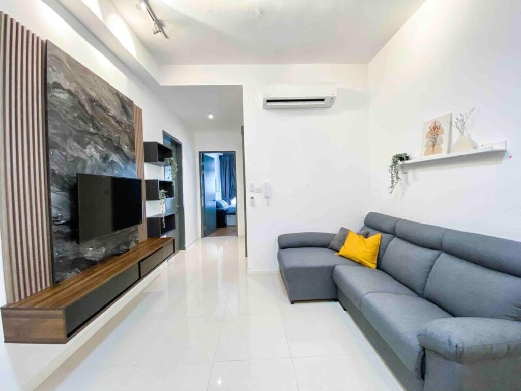 Paradigm Residence Johor Bahru في جوهور باهرو: غرفة معيشة مع أريكة زرقاء وتلفزيون بشاشة مسطحة