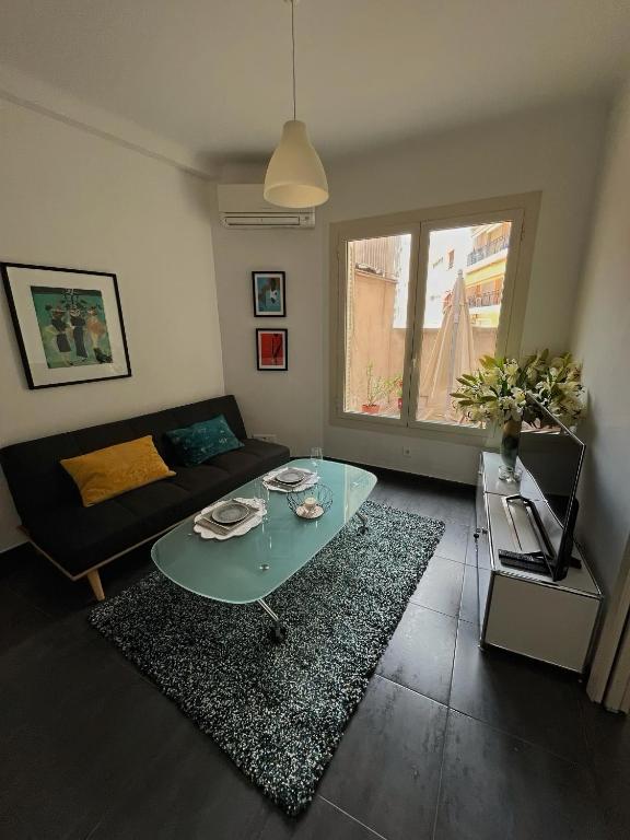 un salon avec une table en verre et un canapé dans l'établissement Perfectly located holiday place, à Beaulieu-sur-Mer