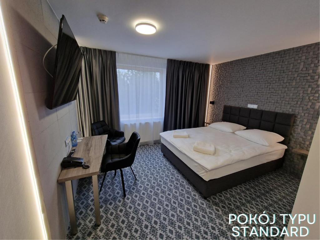 Pokój hotelowy z łóżkiem i biurkiem w obiekcie Hotel Gordon w Warszawie