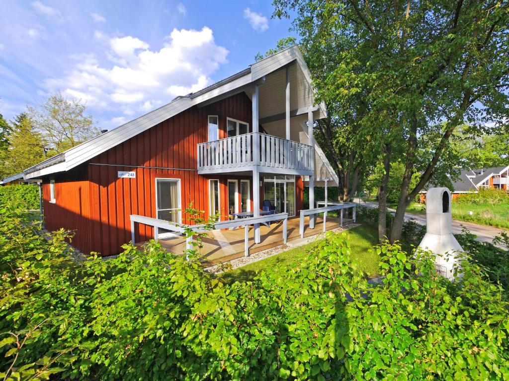 a red house with a porch and a balcony at Wildgans Classic 248 in Mirow