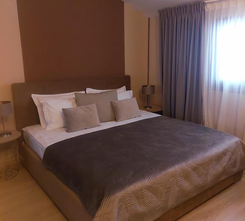 un grande letto in una camera da letto con finestra di Apartaments Victoria a Poreč (Parenzo)