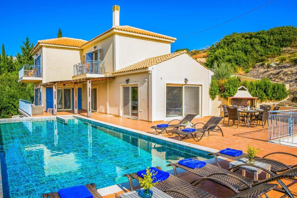 a villa with a swimming pool in front of a house at Villa Louloudia in Ratzaklíon