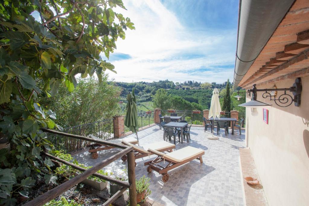 patio ze stołem i krzesłami w obiekcie Garden Relais Le Fontanelle w mieście Montescudaio