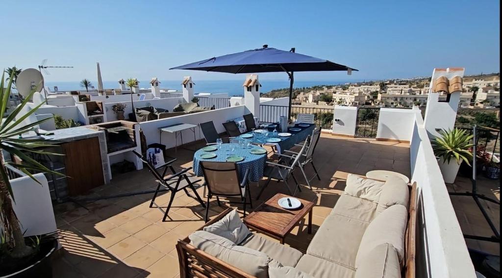 Un patio con una mesa y sillas y una sombrilla. en Cozy Duplex Niza Beach, en Torre del Mar