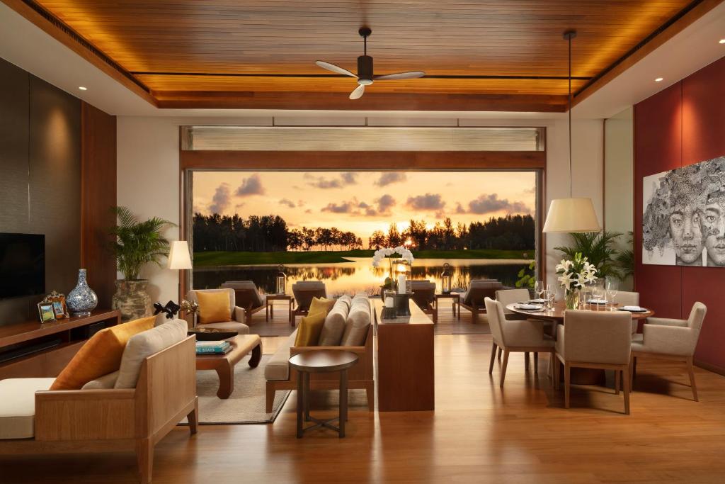 a living room with furniture and a large window at Aquella Lakeside Villas in Thai Muang