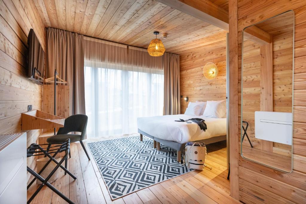 um quarto com uma cama num quarto de madeira em Hôtel le Bout du Parc em Versalhes