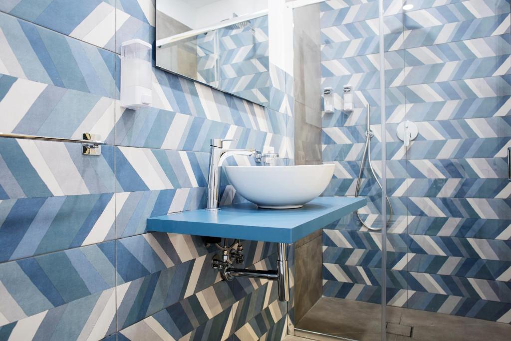 a bathroom with a bowl sink on a blue table at Bausan Avenue in Naples