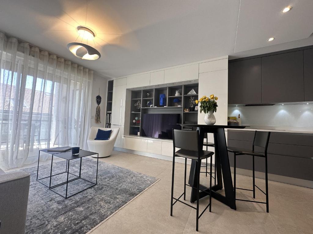 une cuisine avec des armoires noires, une table et des chaises dans l'établissement Appartement centre ville 7 Lecerf, à Cannes