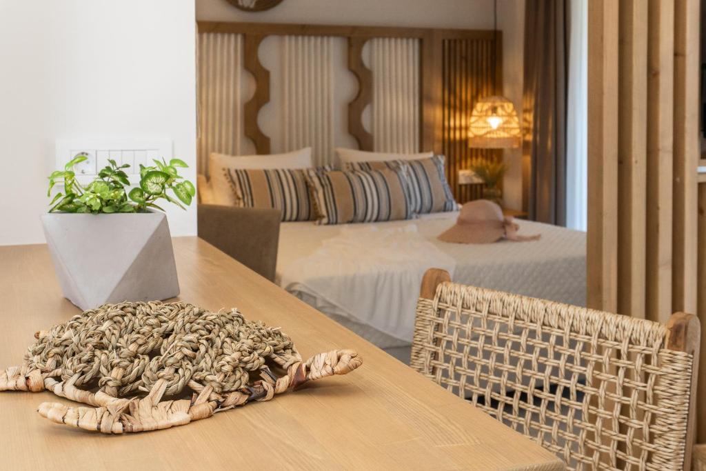 una camera con due letti e un tavolo con una sedia in rattan di Nikos Studios a Keríon