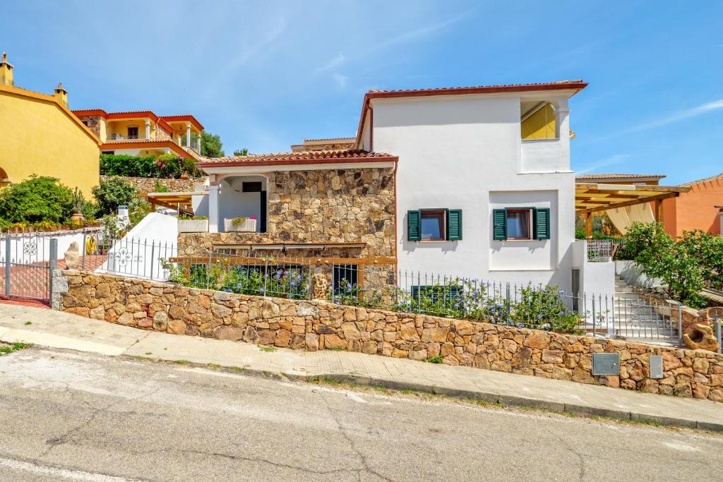 a white house with a stone wall at Villa Poldina in Budoni