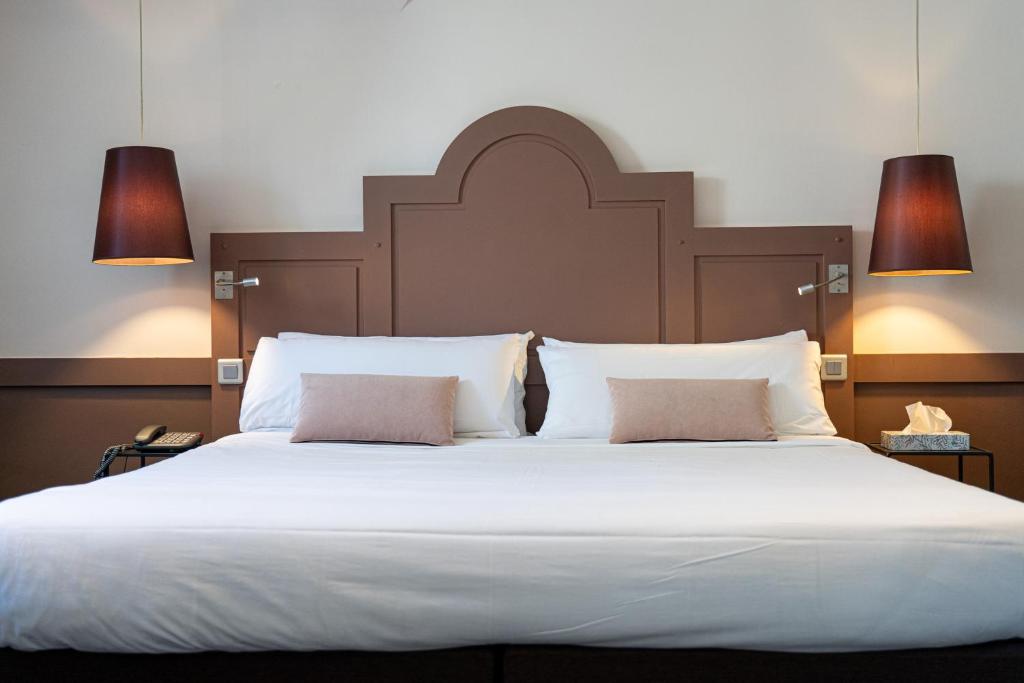 Un pat sau paturi într-o cameră la La Maison des Armateurs