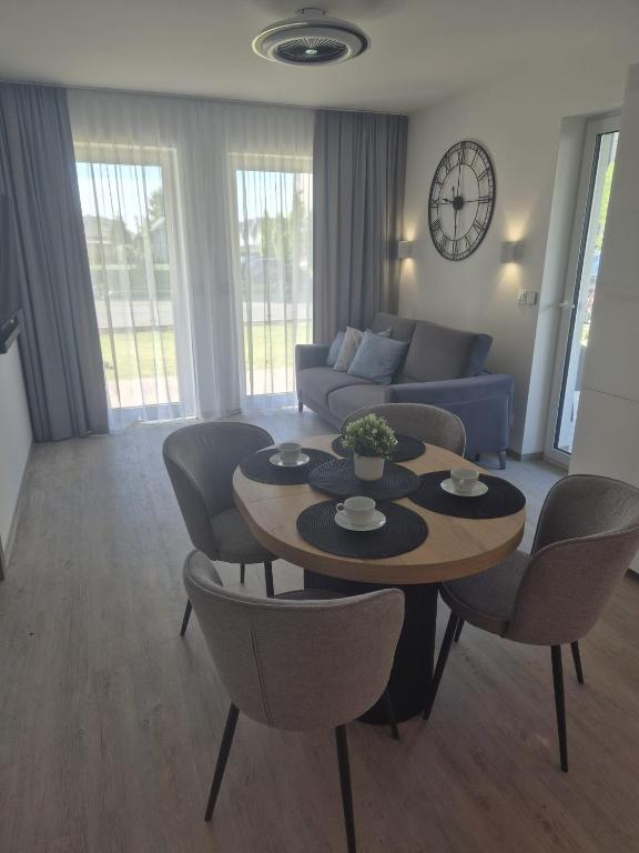 a living room with a table and chairs and a couch at Sonia Pearl Apartament z parkingiem in Sianozety