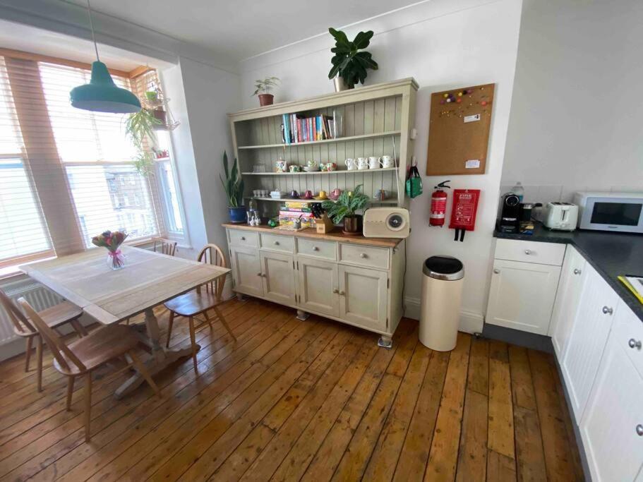 a kitchen with a table and a dining room at Herne Bay Central - 2 minutes from beach apartment in Herne Bay