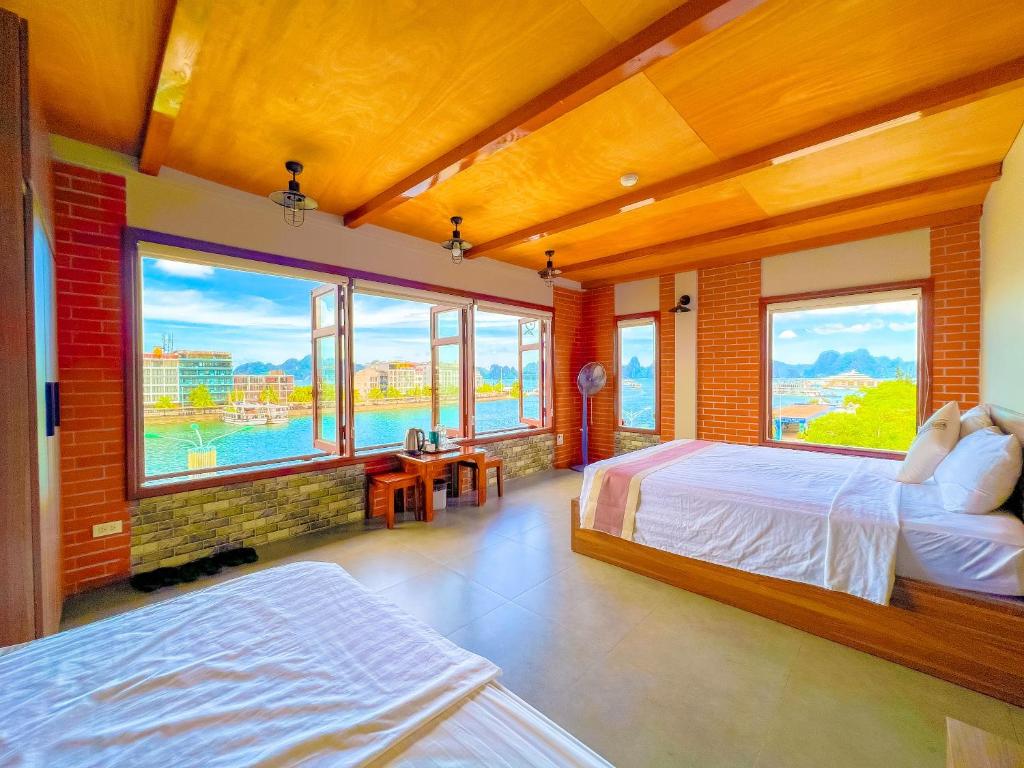 下龍灣的住宿－Cánh Buồm Homestay - Tuần Châu，一间卧室设有两张床和大窗户