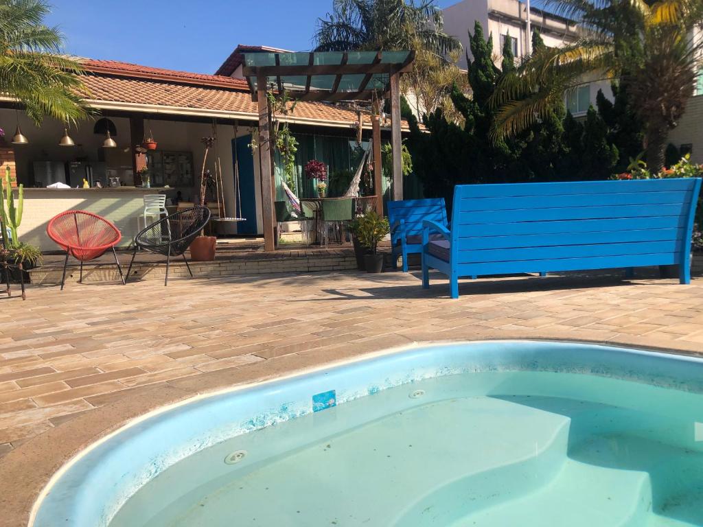 una piscina con un banco azul en un patio en Casa Suakasa Temporada Praia de Itaparica en Vila Velha