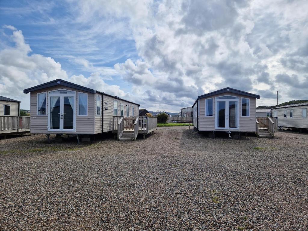 dwie przyczepy mieszkalne są zaparkowane na polu żwirowym w obiekcie Machrihanish Holiday Park w mieście Campbeltown