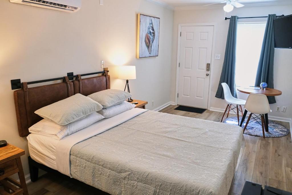 a bedroom with a bed and a table and a window at Cozy Studio - Walk to the Beach! in Jacksonville Beach