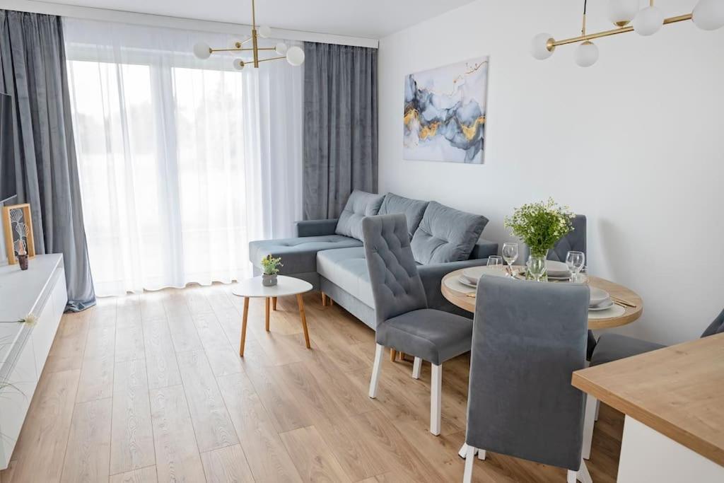 a living room with a blue couch and a table at Apartament Ponidzie in Zbludowice