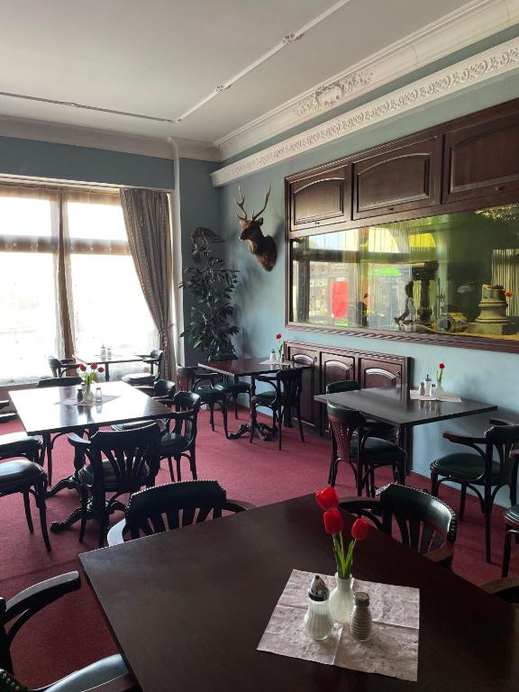 a dining room with tables and chairs in a restaurant at Hotel Černý Orel Žatec in Žatec