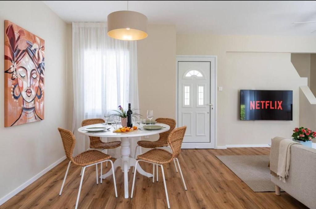Un comedor con una mesa y sillas blancas. en Cozy Nerina Cottage at Harbour Paphos, en Pafos