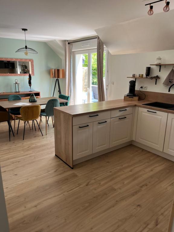 une cuisine avec des placards blancs et une salle à manger dans l'établissement Non disponible, à Miniac-Morvan