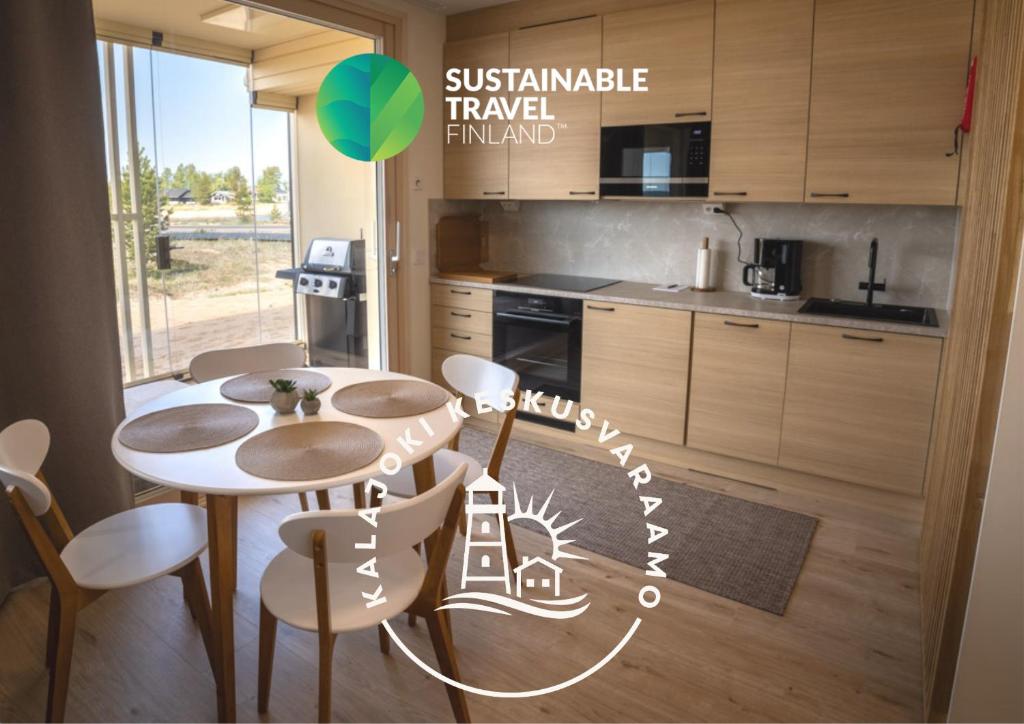 une cuisine avec une table et des chaises dans une pièce dans l'établissement Marina Resort C1, à Kalajoki