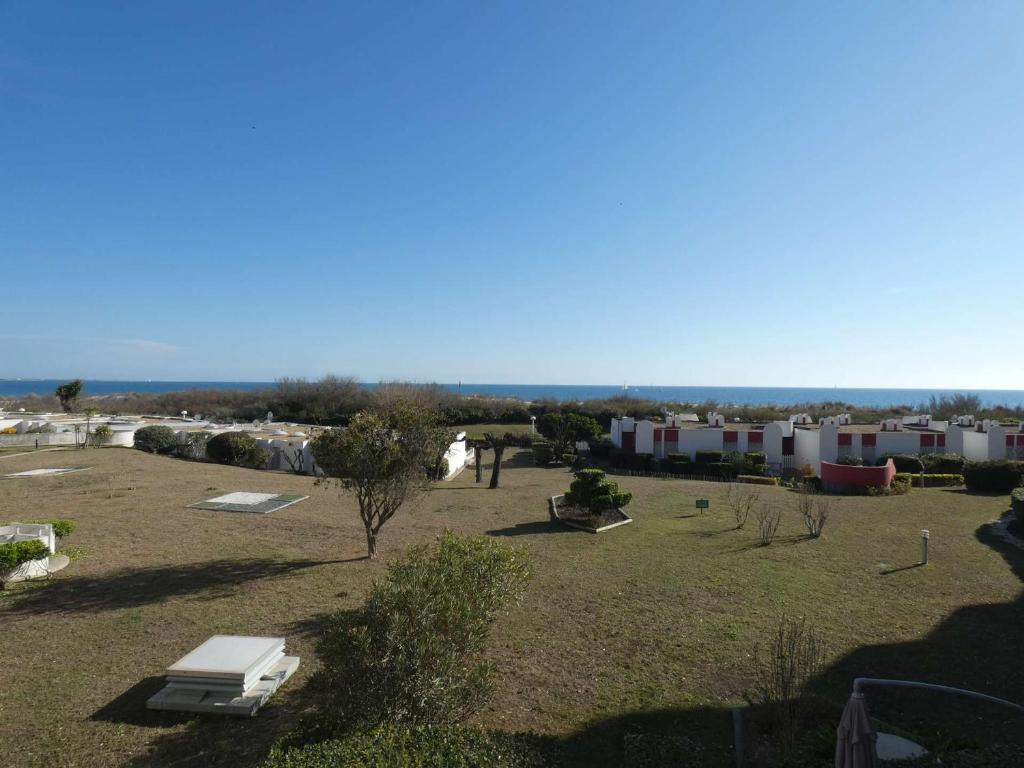 un parc avec un banc et des bâtiments en arrière-plan dans l'établissement Appartement 2 Pièces Cabine, Front de Mer, Parking, 4 Pers - FR-1-328-169, à La Grande Motte