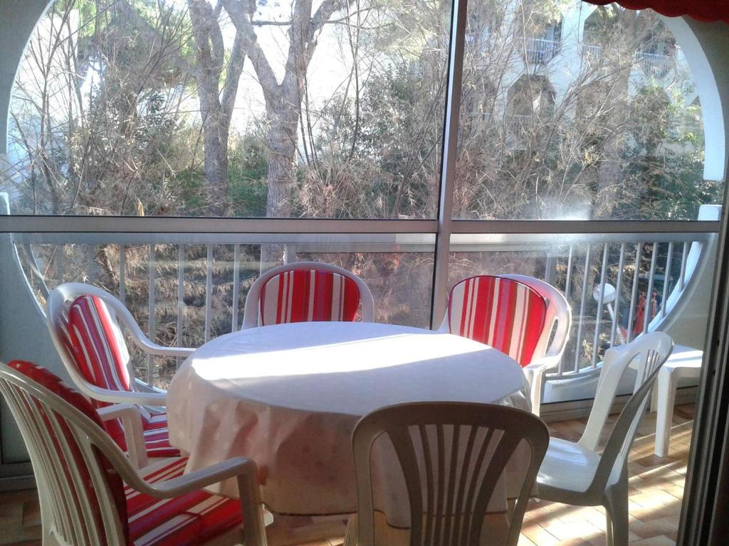 une table et des chaises sur un balcon avec une fenêtre dans l'établissement Spacieux T3 au Centre de La Grande-Motte, 500m Plage, Parking Privé - FR-1-328-139, à La Grande Motte