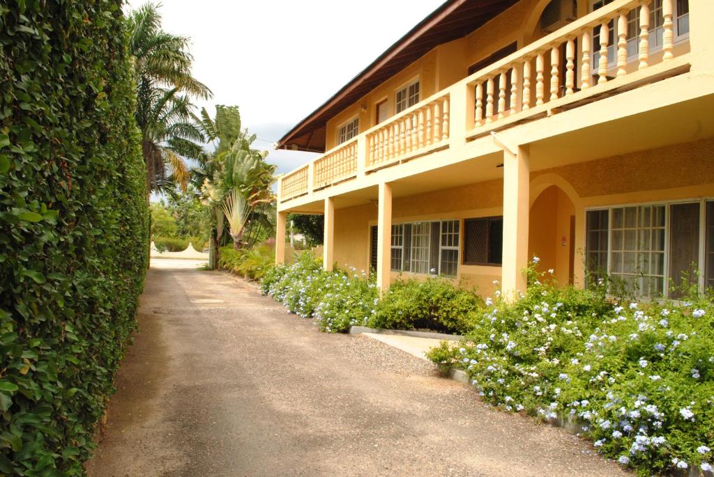 a house with a walkway next to a building at Moonrisevillas in Negril