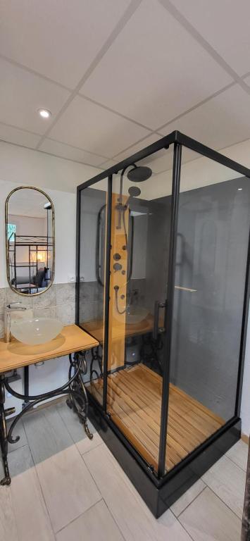 - une salle en verre avec une table et un miroir dans l'établissement Marciac cœur de jazz, à Marciac