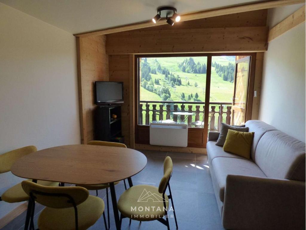 salon z kanapą i stołem w obiekcie Appart rénové 2* pour 6 pers. avec 2 salles d'eau et balcon sud - FR-1-458-178 w mieście Le Chinaillon