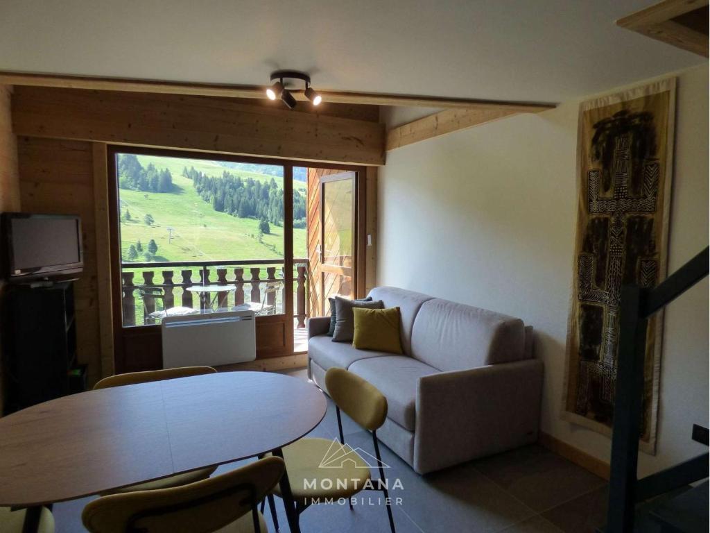 salon z kanapą i stołem w obiekcie Appart rénové 2* pour 6 pers. avec 2 salles d'eau et balcon sud - FR-1-458-178 w mieście Le Chinaillon