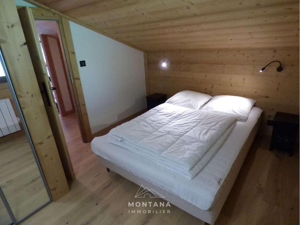 Łóżko w drewnianym pokoju z drewnianą podłogą w obiekcie Appart rénové 2* pour 6 pers. avec 2 salles d'eau et balcon sud - FR-1-458-178 w mieście Le Chinaillon