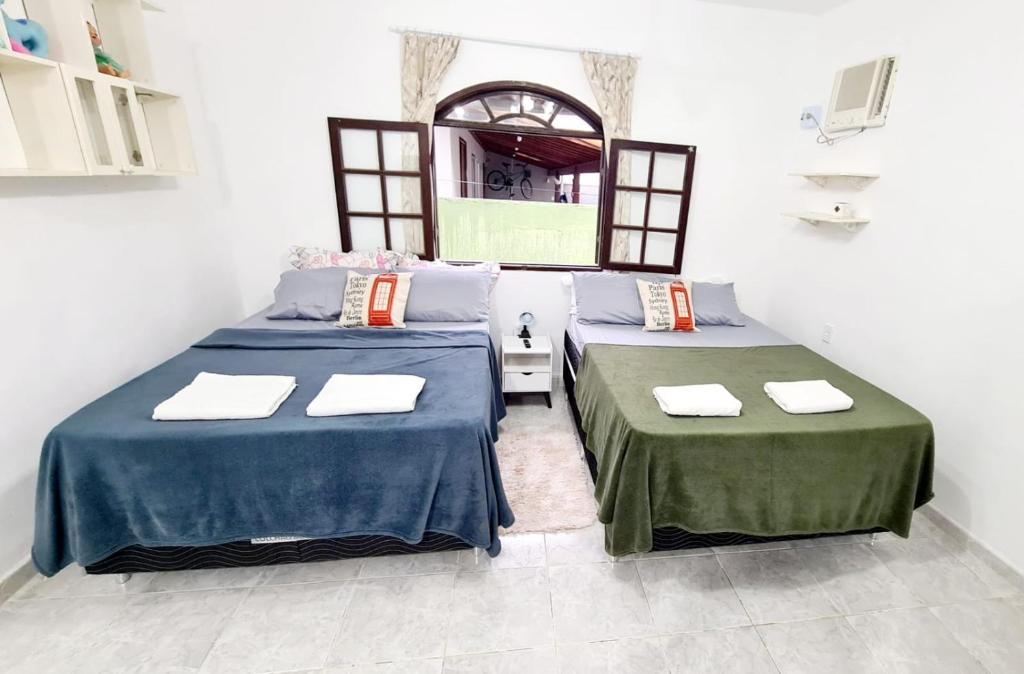 une chambre avec deux lits et une fenêtre dans l'établissement Cantinho da Cake, à Araruama