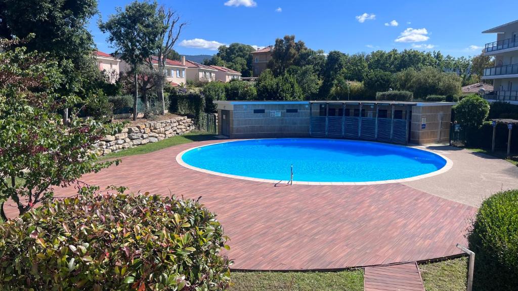 une grande piscine dans une cour en briques rouges dans l'établissement Appartement 2 chambres dans résidence avec piscine et parking, à La Ciotat