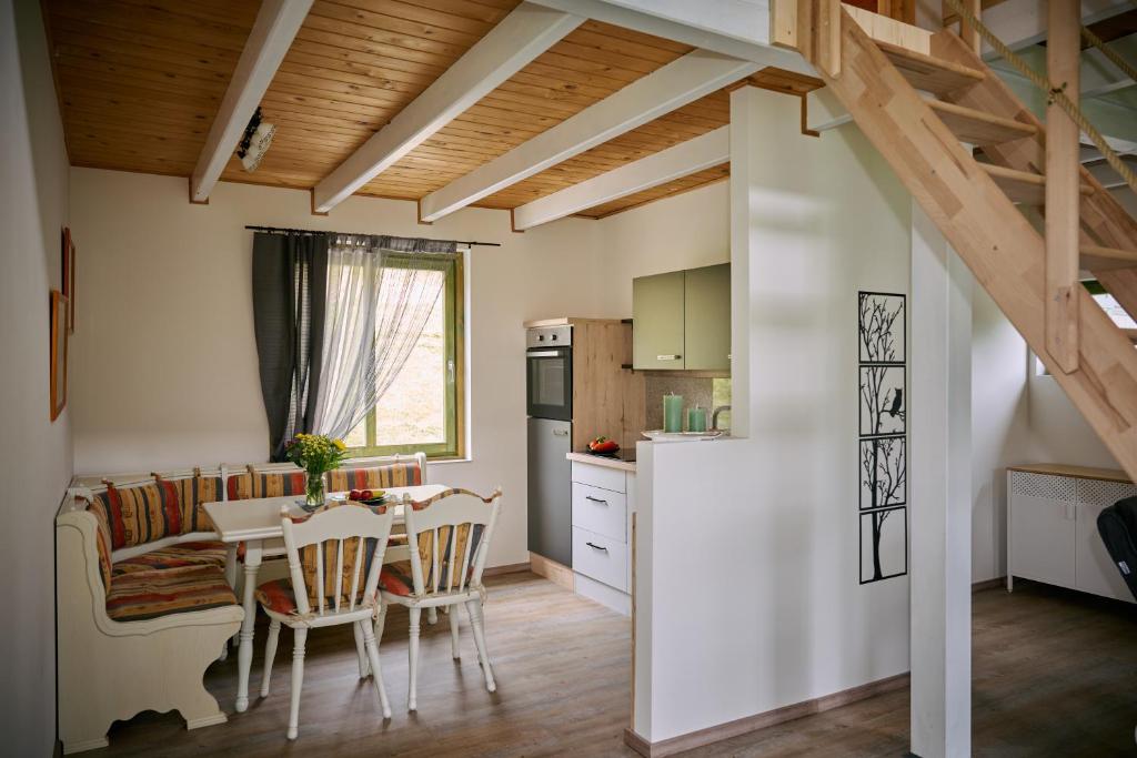 een keuken en eetkamer met een tafel en stoelen bij Kantor Village am Millstätter See - Boutique-Chalets und Lodges in Millstatt