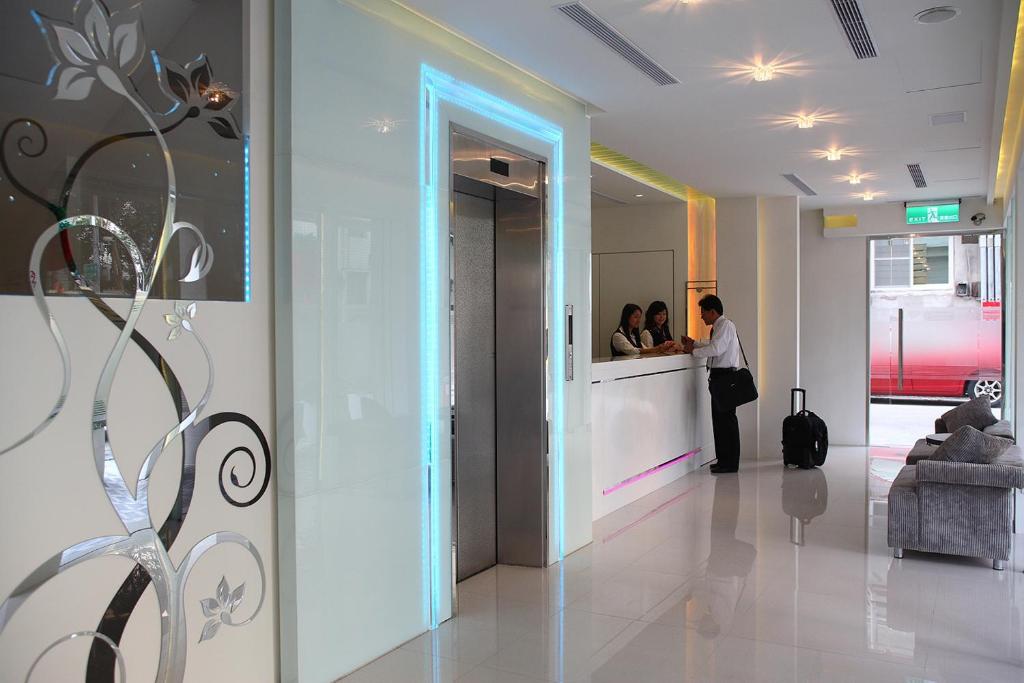 a group of people standing at a counter in a lobby at Hsiangkelira Hotel in Kaohsiung