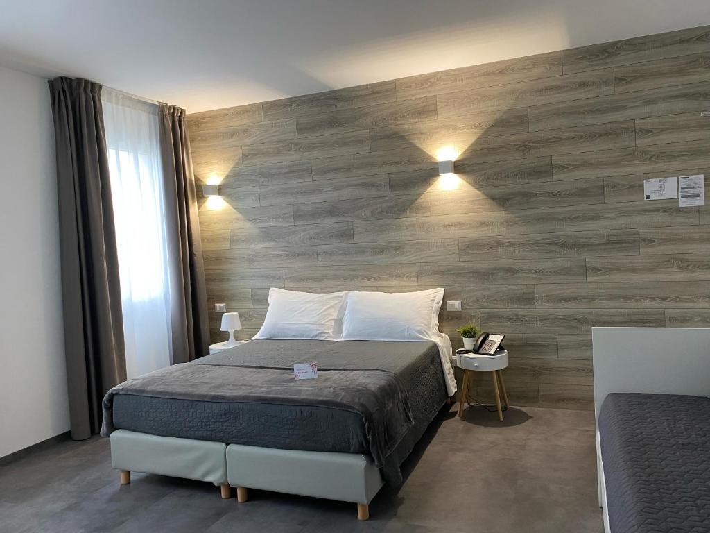 a bedroom with a bed and a wooden wall at Boutique Hotel Nuovo Cason in Cavallino-Treporti
