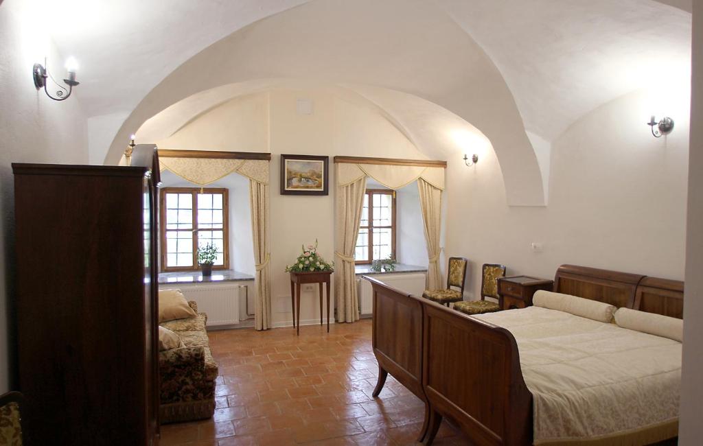 a bedroom with a bed and a couch in a room at Grad Tuštanj in Moravče