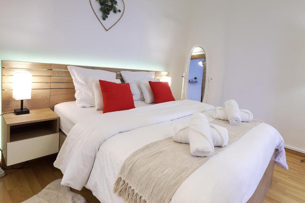 - une chambre avec 2 lits dotés de draps blancs et d'oreillers rouges dans l'établissement Le Scarlett Nîmois, à Nîmes