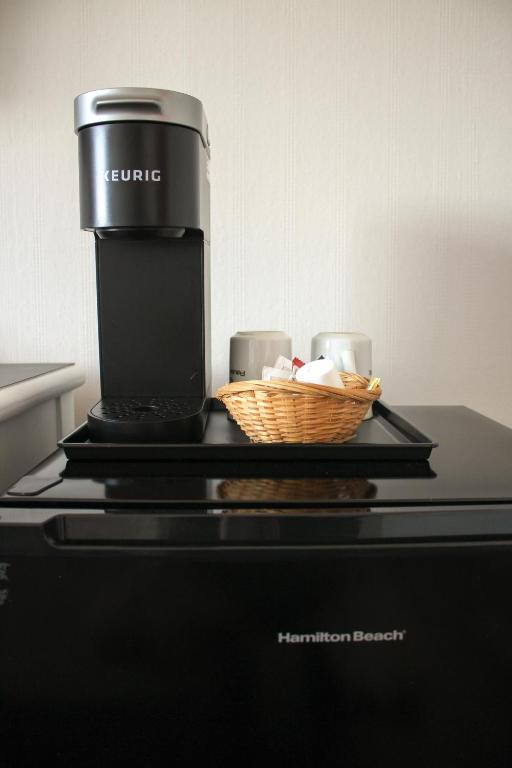 a coffee maker with a basket on top of a microwave at Auberge le Parasol in Saguenay