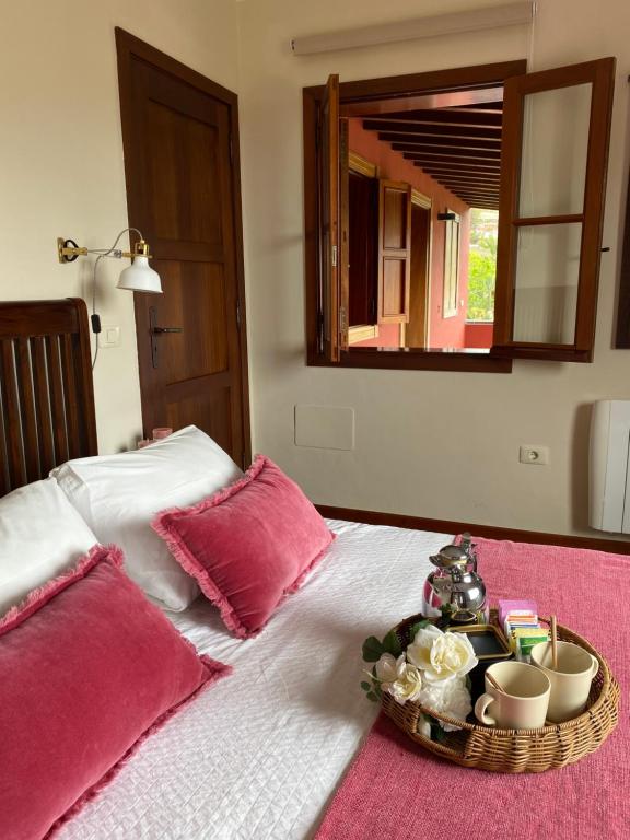 a bed with a tray with cups and flowers on it at Casa Rural El Chorrito in Buenavista del Norte