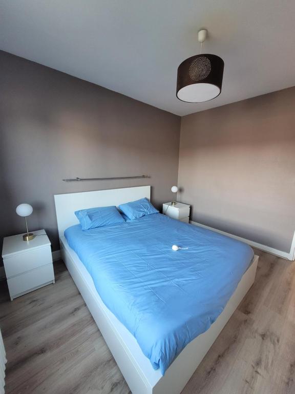 une chambre avec un grand lit avec des draps bleus dans l'établissement Résidence Malouine 