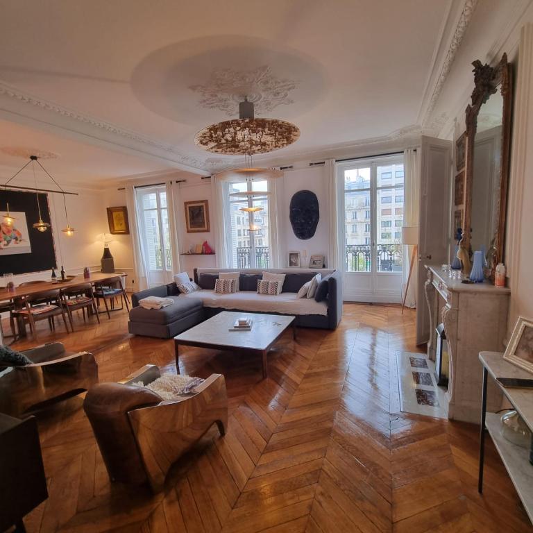 un salon avec un canapé et une table dans l'établissement Haussmannien Appartement 10 min Champs-Élysées, à Neuilly-sur-Seine